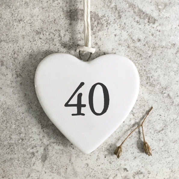 White heart-shaped ornament with the number 40 on a gray concrete surface