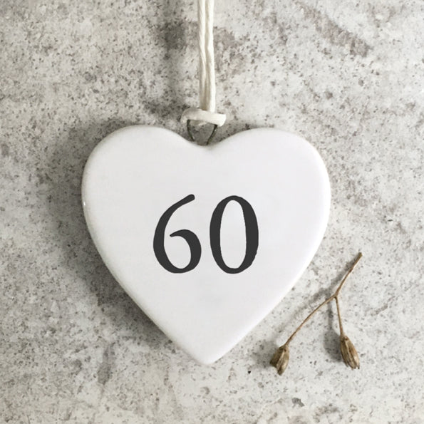 White heart-shaped ornament with '60' on a textured gray surface