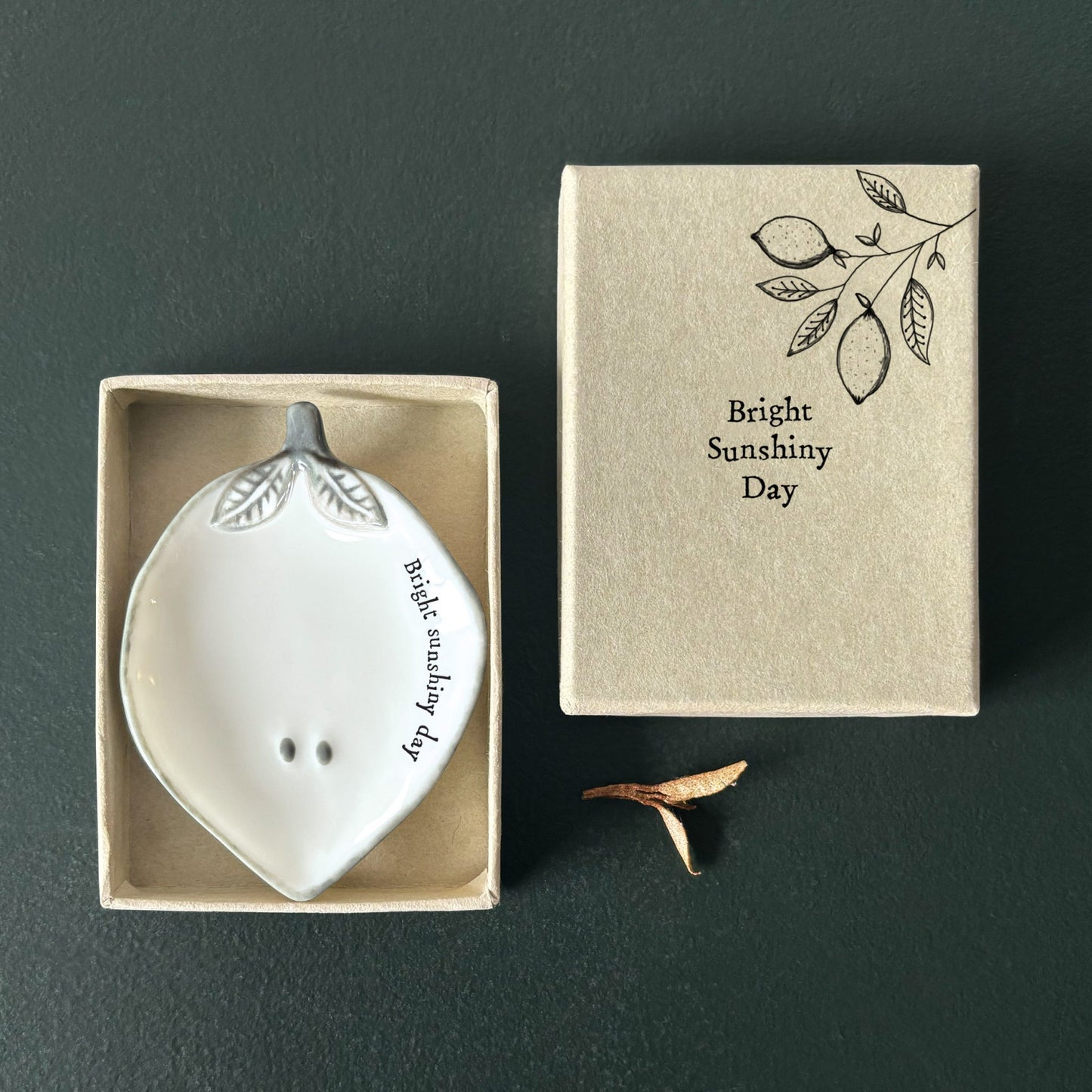 White ceramic lemon shaped dish with 'Bright Sunshiny Day' text in a matching box on a dark background