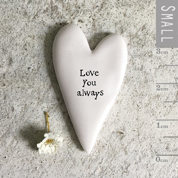 White heart-shaped ceramic ornament with 'Love You always' text on a textured surface with a small ruler for scale.