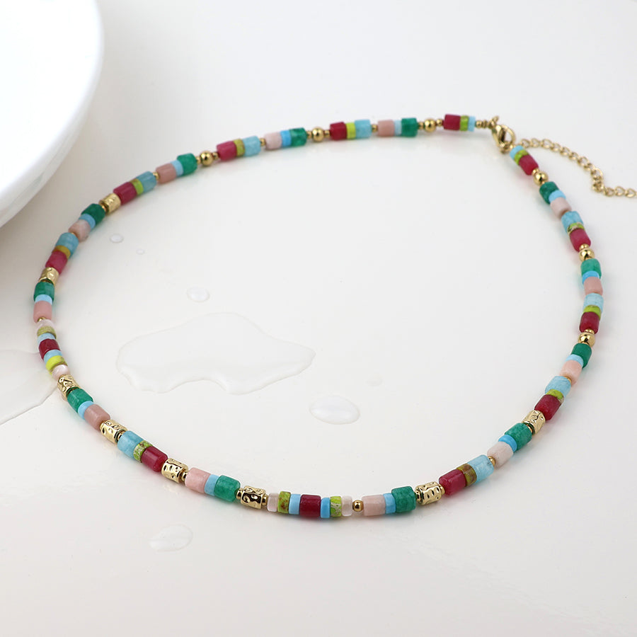 Colorful beaded necklace with gold accents on a white background