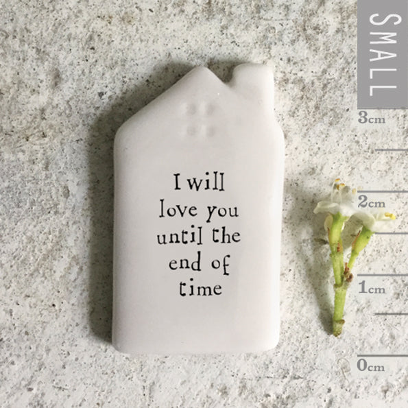 Small white ceramic house plaque with 'I will love you until the end of time' text on a textured surface with measurement scale.