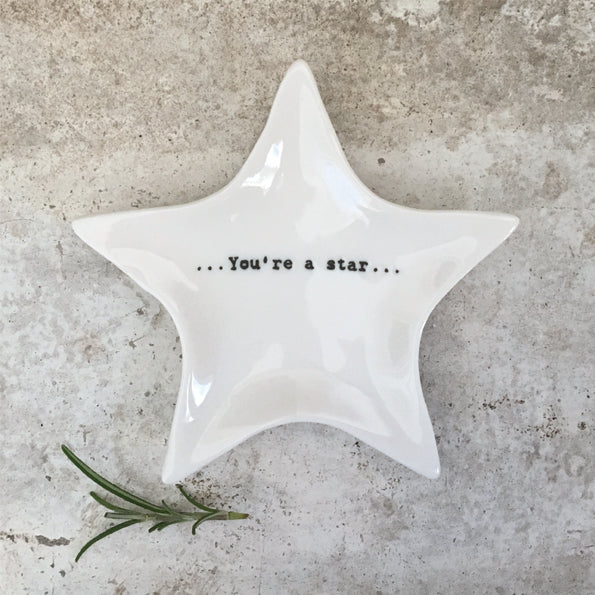 Star-shaped white dish with 'You're a star' text on a gray surface